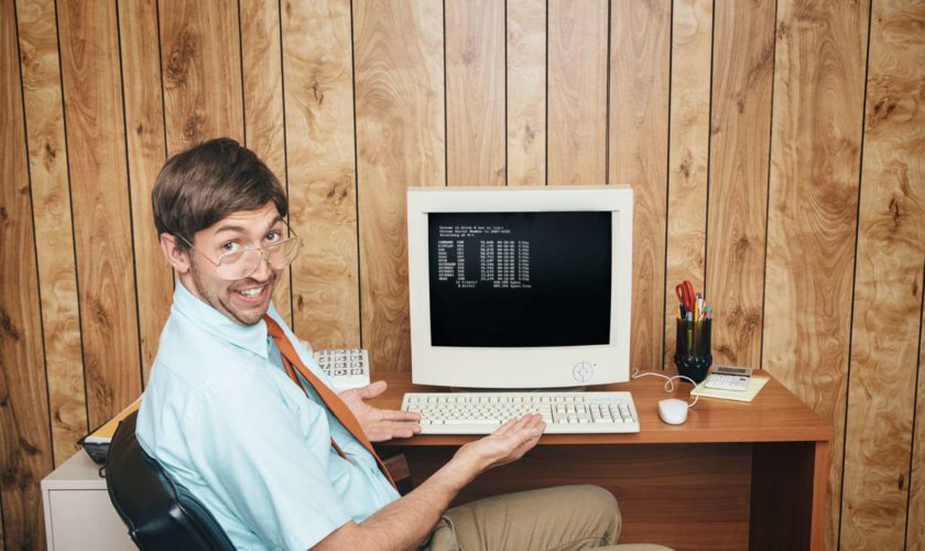 Büroangestellter sitzt vor seinem PC - Bürojob in der Vergangenheit - Computer - Humor